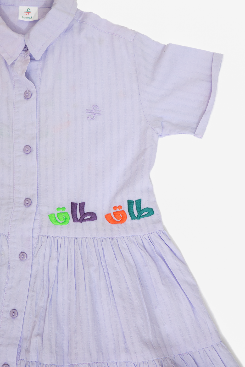 Light purple short sleeve dress with button front and colorful embroidered design on waist
