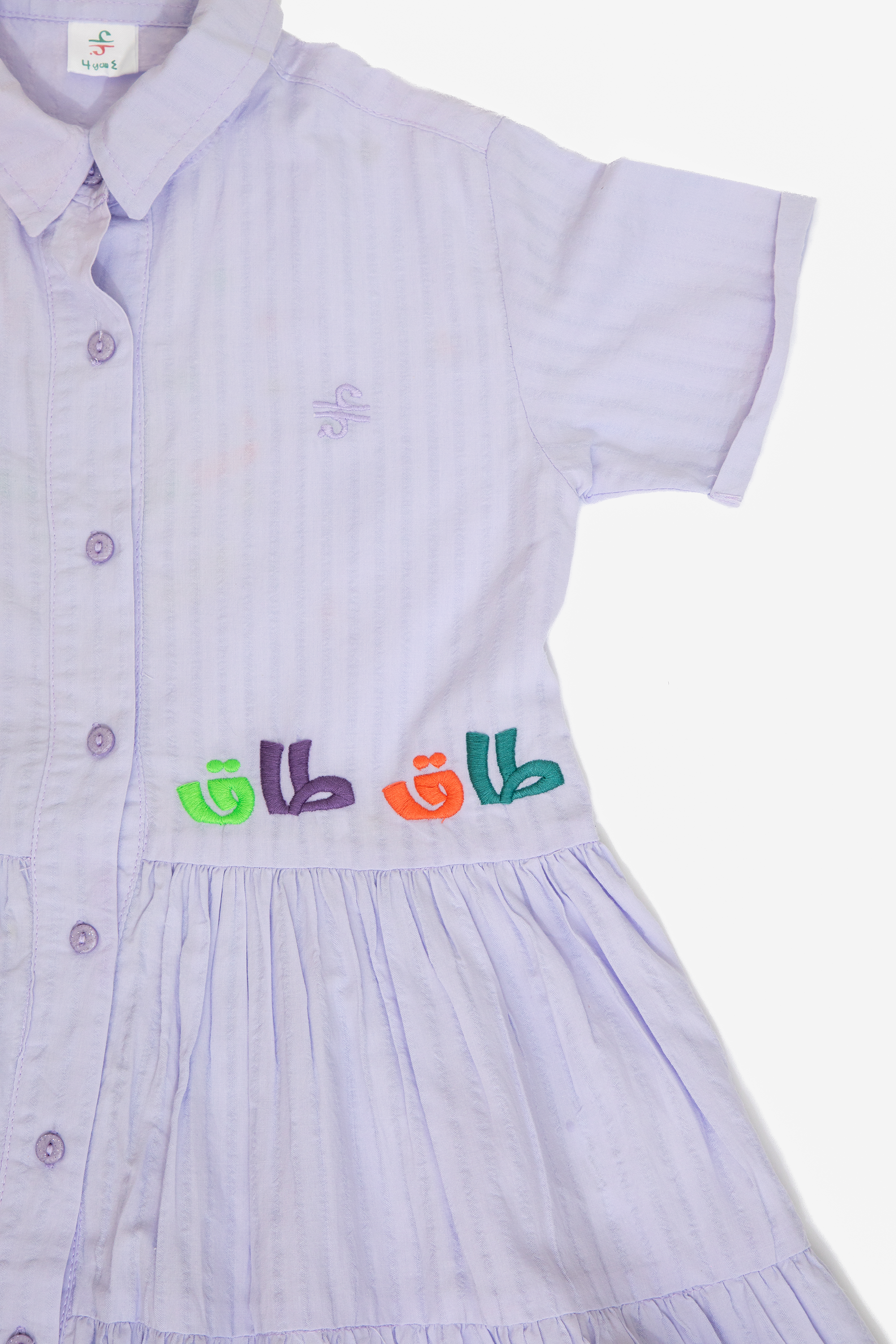 Light purple short sleeve dress with button front and colorful embroidered design on waist